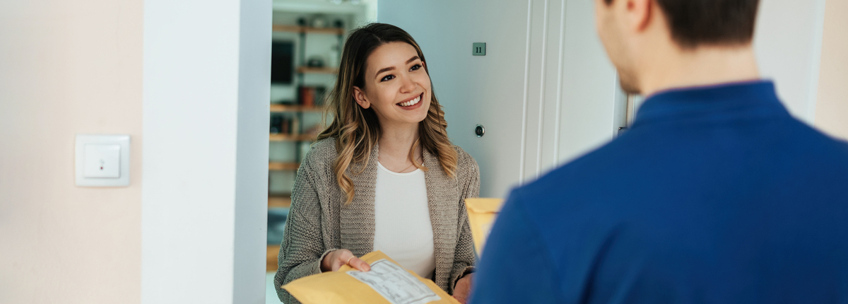 happy woman taking package from courier while receiving home delivery 1